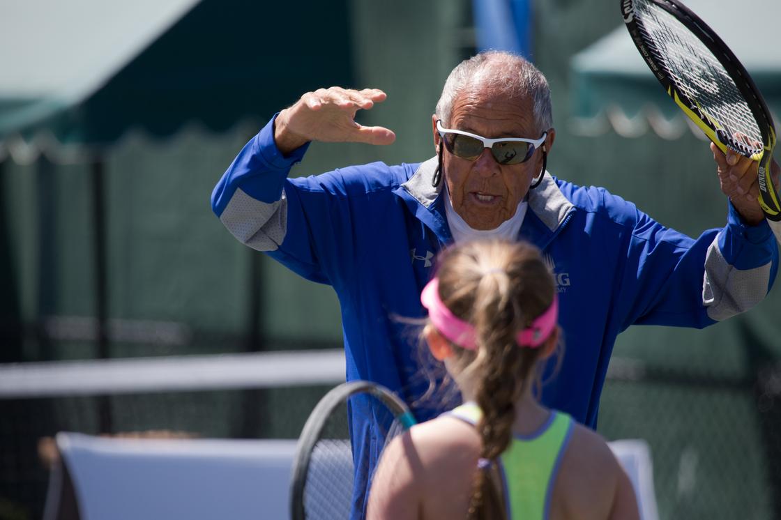 Legandary Coach Nick Bolletieri, from IMG Tennis Academy coaching one of his students in one of Miami Open's secondary courts. IMG academy is the best tennis academy in North America