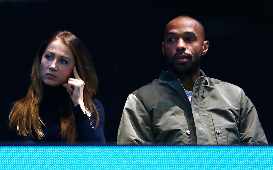 Footballer Thierry Henry and his wife Nicole Merry sit in front of