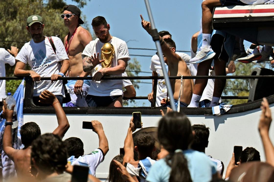 Lionel Messi cuddled the World Cup and waved to fans at the start of the victory parade in Buenos Aires in December