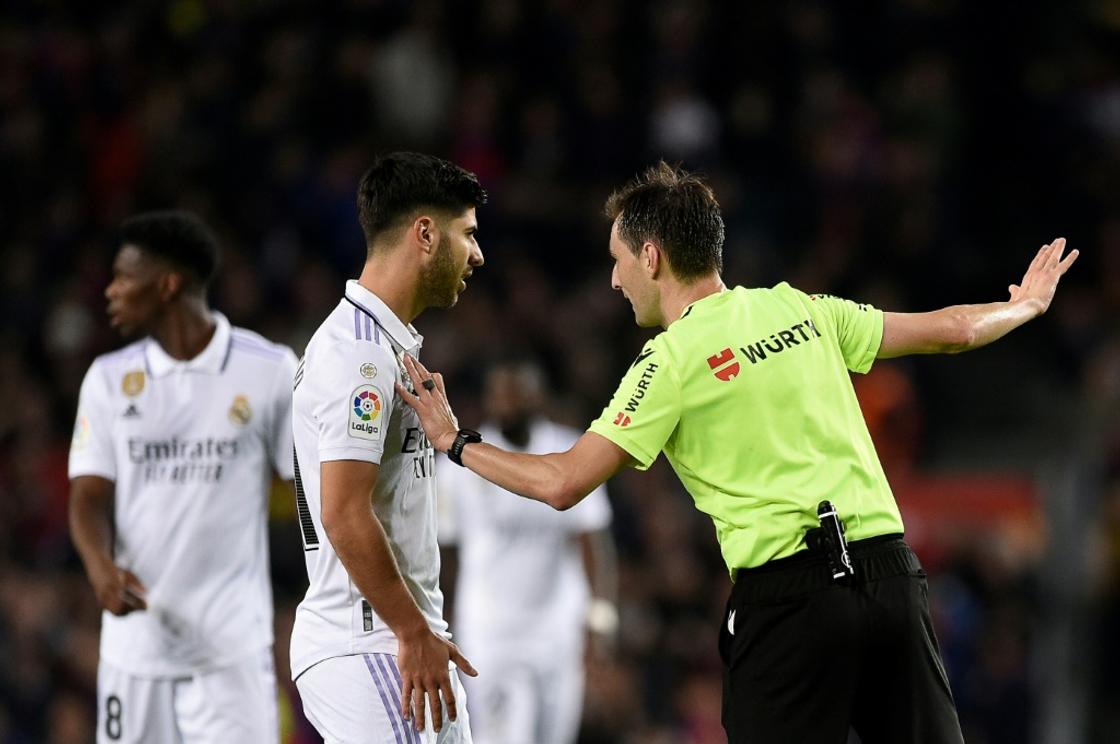 Spanish referee Ricardo De Burgos Bengoetxea (R) talks to Real Madrid's Spanish midfielder Marco Asensio after annulling his goal
