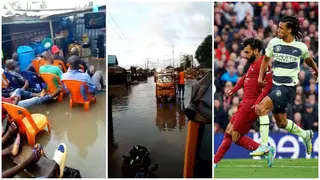 Football fans defy floods in Nigerian community, chill inside waters to watch Liverpool vs Man City