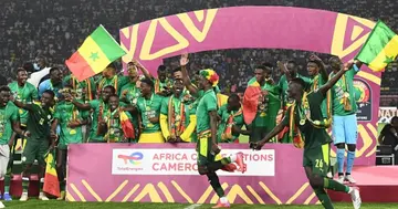 Senegal's players celebrate on the podium after winning the Africa Cup of Nations (CAN) 2021 final football match between Senegal and Egypt at Stade d'Olembe in Yaounde on February 6, 2022. (Photo by CHARLY TRIBALLEAU)