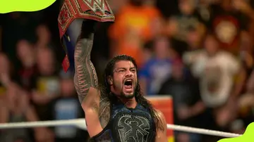 Roman Reigns shows his belt before battling Brock Lesnar in Universal Championship match 