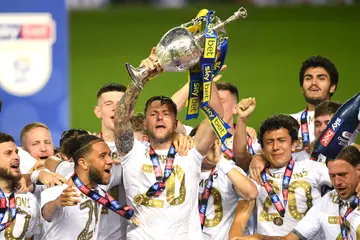 Liam Cooper of Leeds United lifts the trophy in celebration