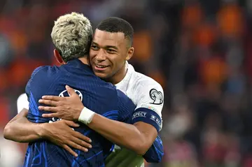 France forwards Antoine Griezmann and Kylian Mbappe em,brace after securing Euro 2024 qualification