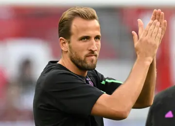 Harry Kane applauds the Bayern Munich supporters as he warms up for the German Super Cup match