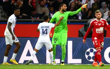 PSG goalkeeper Gianluigi Donnarumma celebrates with Juan Bernat after saving Islam Slimani's penalty against Brest