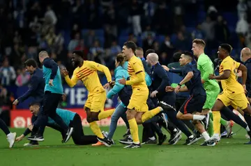 Quick exit: Barcelona's players leave the pitch in a hurry as Espanyol fans invade the pitch