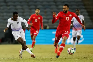 Nader Ghandri (R) of Tunisia fails to block a shot by Bethuel Muzeu of Namibia in a 2026 World Cup qualifier in Soweto, South Africa.