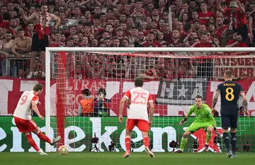 Bayern Munich's Harry Kane (L) rolls home his penalty in the Champions League semi-final first leg against Real Madrid