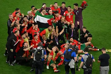 Morocco's players hold a Palestinian flag aloft after their World Cup victory over Spain
