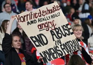 Supporters at Wembley hold up a banner protesting against abuse in women's football