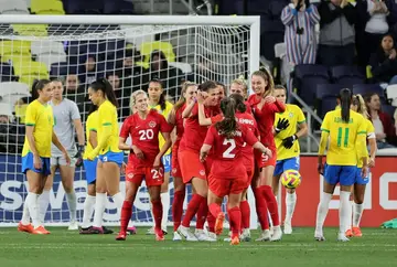Reigning Olympic women's football champion Canada, celebrating a goal against Brazil at the SheBelieves Cup, has been set for an April match in France but are playing under protest to obtain equal backing as their male counterparts