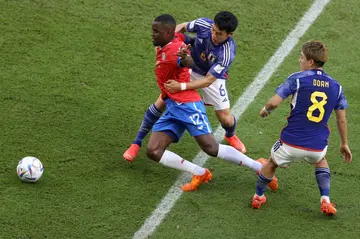Costa Rica forward Joel Campbell tries to get away from the Japan defence