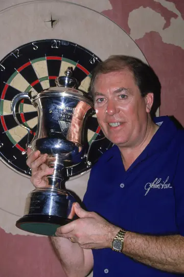 Which dart player has won the most trophies?