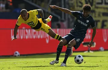 Dortmund goalscorer Donyell Malen goes flying in a challenge with  Bochum defender Bernardo