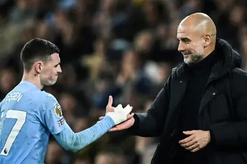 Manchester City manager Pep Guardiola (R) congratulates Phil Foden following the midfielder's hat-trick in a 4-1 win over Aston Villa
