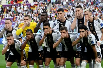 Germany's starting XI including Chelsea forward Kai Havertz (third from right, top) cover their mouths in protest against FIFA before Tuesday's match against Japan