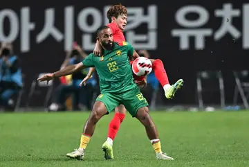 South Korea's Kim Jin-su (top) fights for the ball with Cameroon's Bryan Mbeumo in Seoul