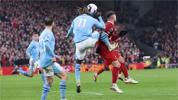 Jeremy Doku kicks Alexis Mac Allister during the Premier League match between Liverpool FC and Manchester City at Anfield. Photo by Alex Livesey.