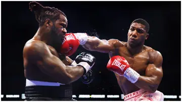 Anthony Joshua lands a hit on Jermaine Franklin during a previous bout. The British boxer was seen training with Super Eagles legend, Yakubu Ayegbeni in the UK recently.