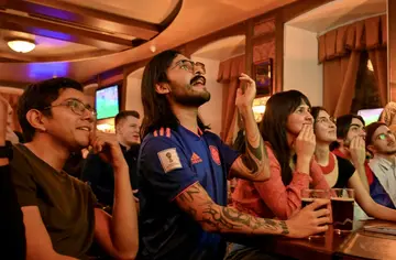 People watch a live broadcast of the 2022 World Cup match between Brazil and Serbia in a pub in Moscow -- Russian fans are lending their support to Serbia with Russia banned from competition over the war in Ukraine