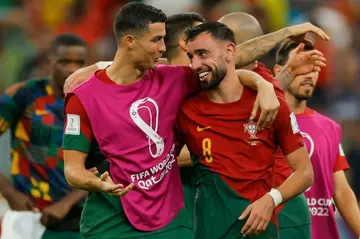 Cristiano Ronaldo (L) and Bruno Fernandes celebrate Portugal's win over Uruguay that clinched a place in the last 16 of the World Cup
