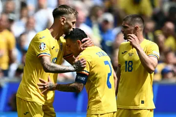 Nicolae Stanciu celebrates with teammates after scoring the opening goal for Romania against Ukraine
