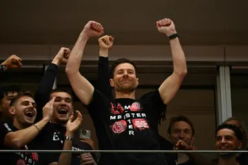 Bayer Leverkusen coach Xabi Alonso celebrates with his players after winning the Bundesliga title