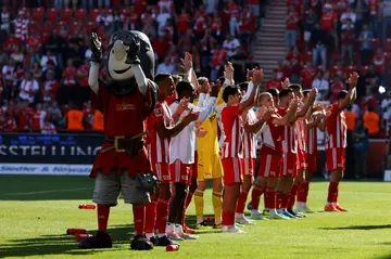 Union Berlin players and  mascot acknowledge their fans after their 3-1 win over city rivals Hertha