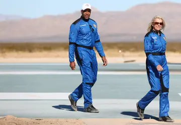 Good Morning America co-anchor and former NFL star Michael Strahan (C) and Laura Shepard Churchley, daughter of astronaut Alan Shepard, walk during a media availability on the landing pad after they flew into space aboard Blue Origin’s New Shepard