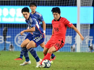 South Korea's Lee Kang-in (R #18) evades a Japan defender