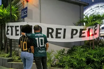 Mourning: Football fans stand in front of a banner reading "Eternal King Pele" outside the Albert Einstein Israelite Hospital in Sao Paulo, where the Brazilian football legend died on Thursday