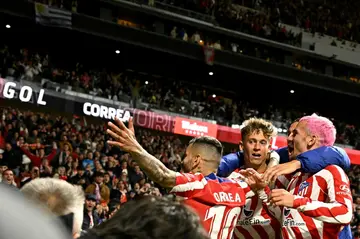 Atletico Madrid forward Angel Correa (L) celebrates with teammates after breaking the deadlock against Real Betis