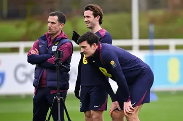 England's Harry Maguire (front R) looks at a smart phone as part of a team training session