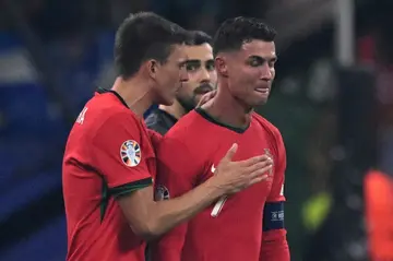 Portugal's Cristiano Ronaldo (R) reacts to his missed penalty kick against Slovenia