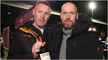 Erik ten Hag presents Graham Coughlan with a bottle of red wine after the Emirates FA Cup Fourth Round match between Newport County and Manchester United. Photo by Matthew Peters.