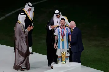 Honoured: Qatar's Sheikh Tamim bin Hamad al-Thani wraps a 'bisht' cloak around Lionel Messi