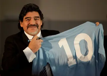 Diego Maradona holds a Napoli number 10 jersey during a press conference in Naples in 2013.