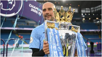 Pep Guardiola celebrates with the Premier League trophy following the Premier League match between Manchester City and Everton at Etihad Stadium. Photo by Michael Regan.