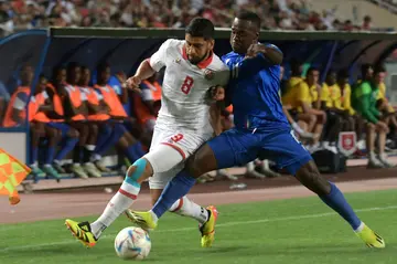 Tunisia midfielder Hamza Rafia (L) and Equatorial Guinea defender Saul Basilo fight for the ball during a 2026 World Cup qualifier in Rades.