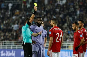 Uruguayan referee Andres Matonte brandishes a yellow card during the Club World Cup semi-final between Real Madrid and Al Ahly