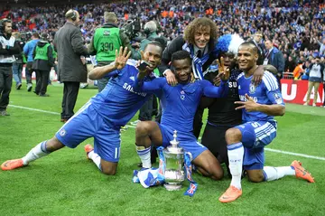 Didier Drogba, Mikel Obi, and Michael Essien celebrate with the FA Cup trophy after Chelsea's victory over Liverpool in 2012. Photo: Nick Potts.