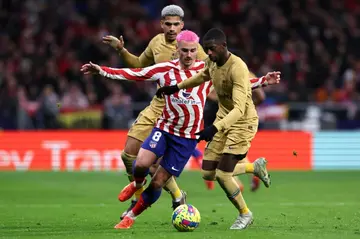 Atletico Madrid's French forward Antoine Griezmann (C) vies with Ousmane Dembele (R), who scored the winner