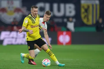 Marco Reus, escaping RB Leipzig's Dani Olmo, has committed to staying at Dortmund