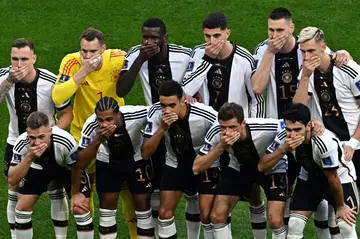 Germany's players cover their mouths as they pose for a picture before their World Cup opener