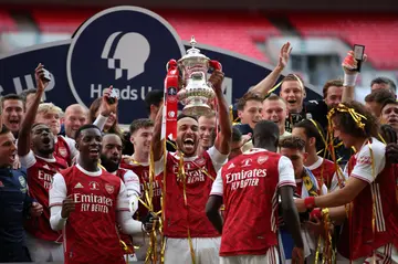 Arsenal's Gabonese striker Pierre-Emerick Aubameyang (C) holds the winner's trophy as the team celebrates victory after the English FA Cup final football match