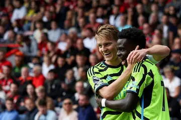 Arsenal's Martin Odegaard (L) and Bukayo Saka are dreaming of Champions League and Premier League glory