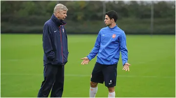 Arsene Wenger talks to Mikel Arteta during a training session at London Colney. Photo by Stuart MacFarlane.