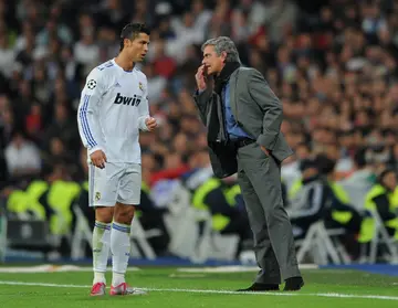 Cristiano Ronaldo and Jose Mourinho having a chat on the sidelines during a game for Real Madrid.